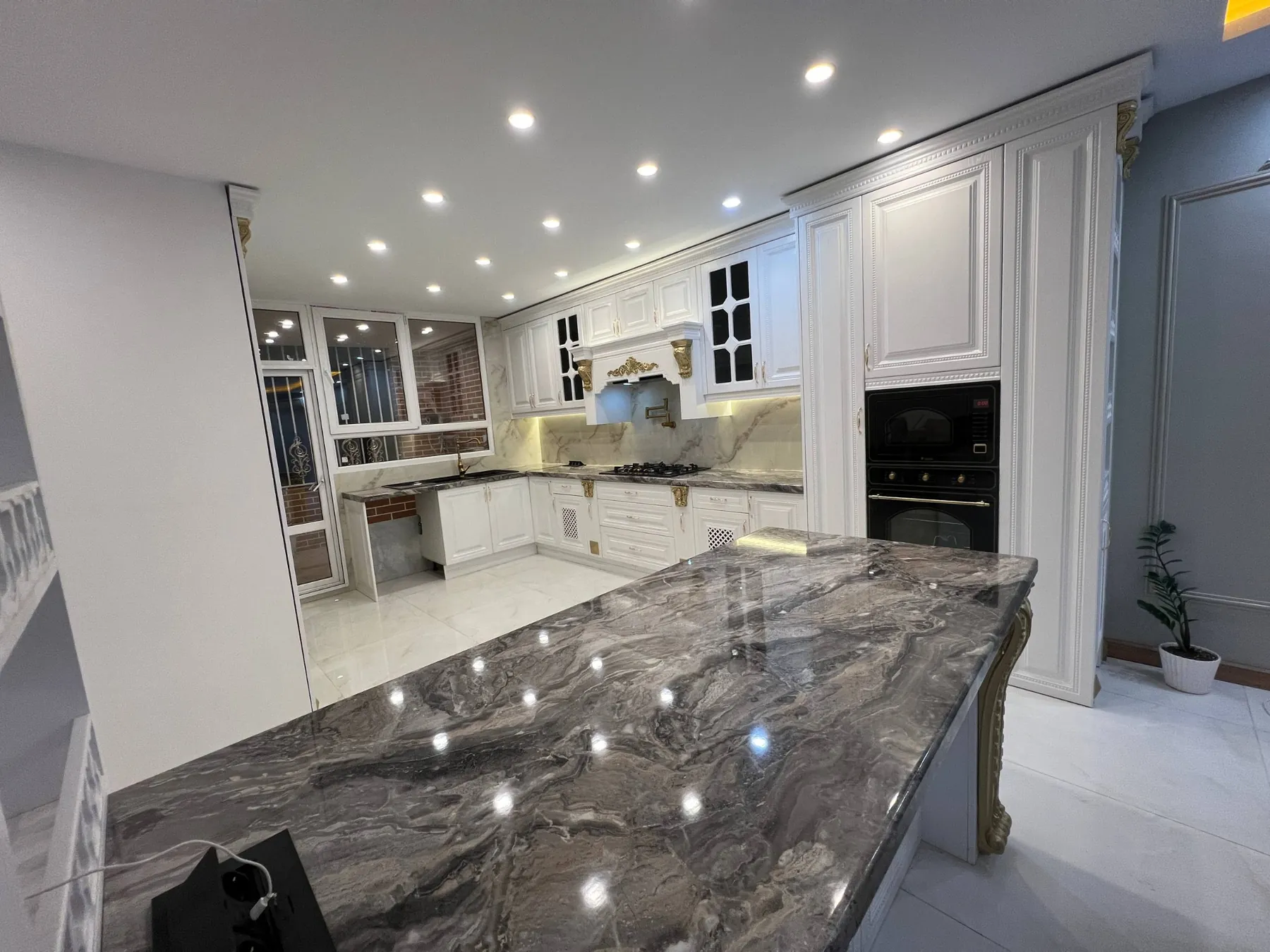 Actual completed dark grey stone-look peninsula countertop with decorative support