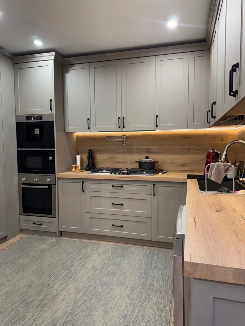 Installed cooktop wall with drawers and warm wood-look backsplash