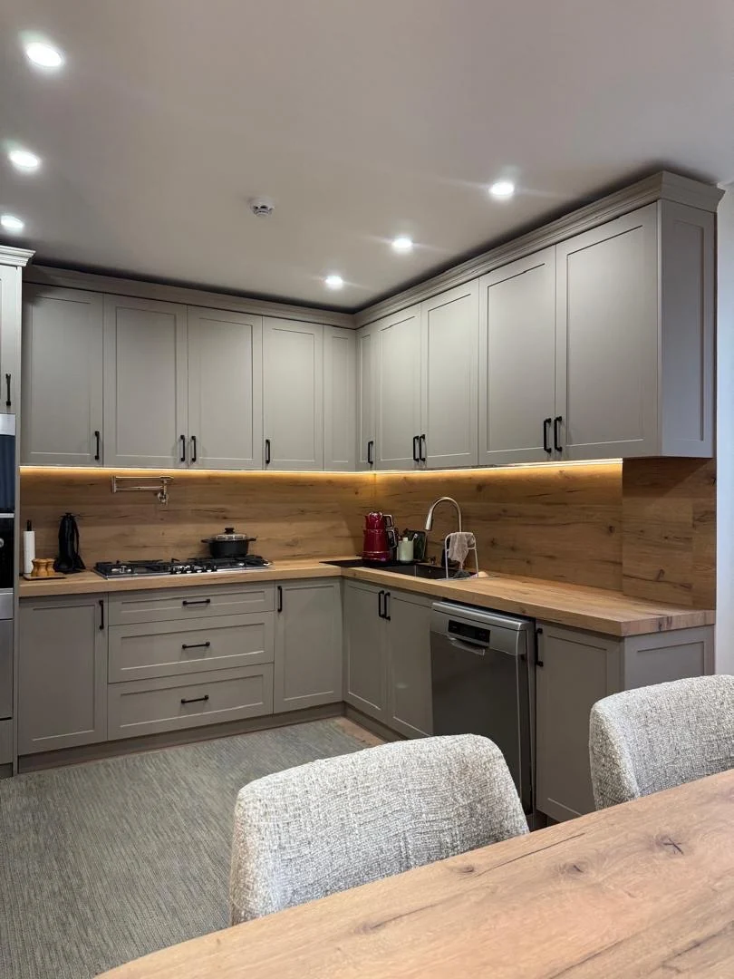 Completed kitchen cabinetry with lighting, worktops and island view